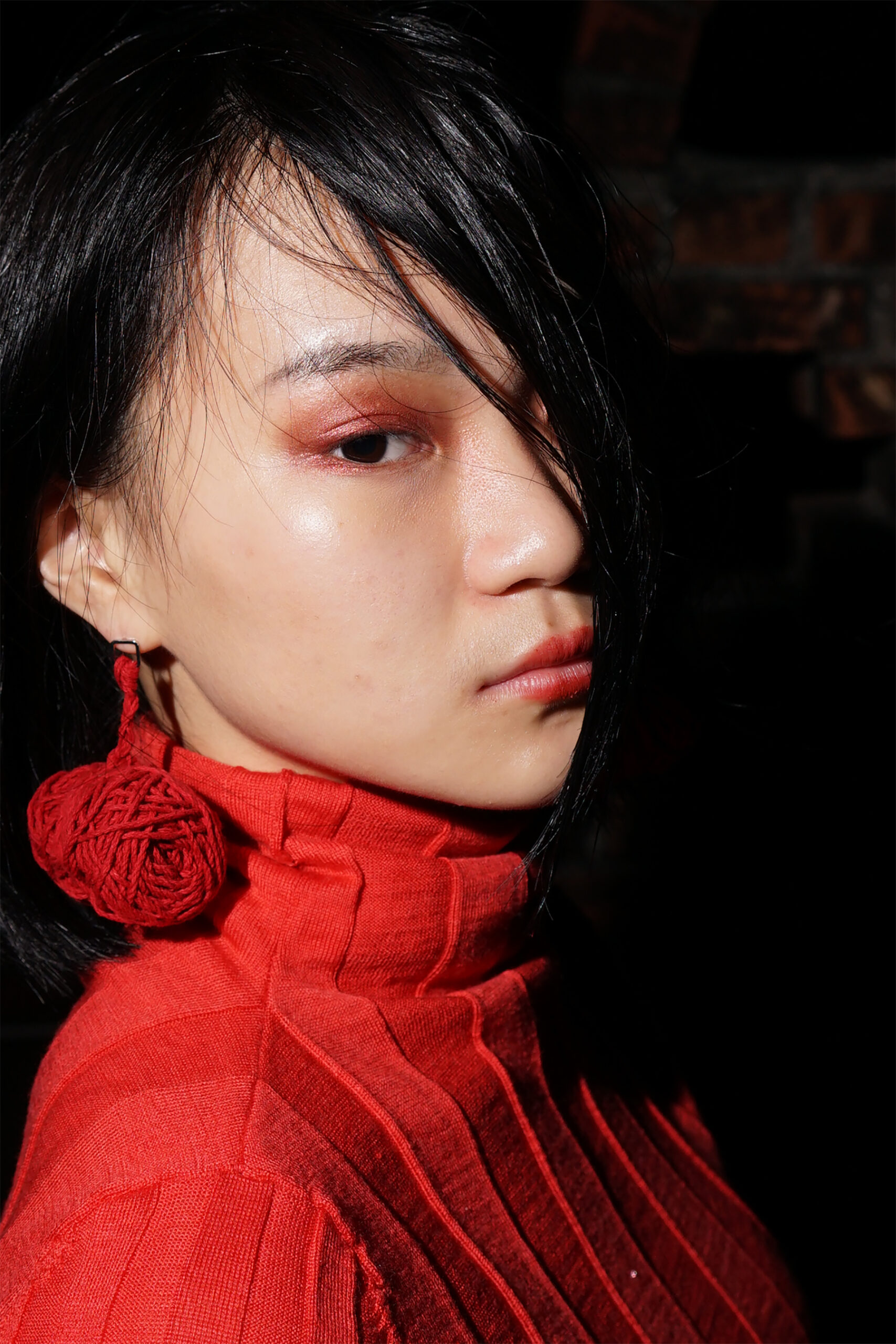 Portrait with Red sweater and red bundle of yarn earing