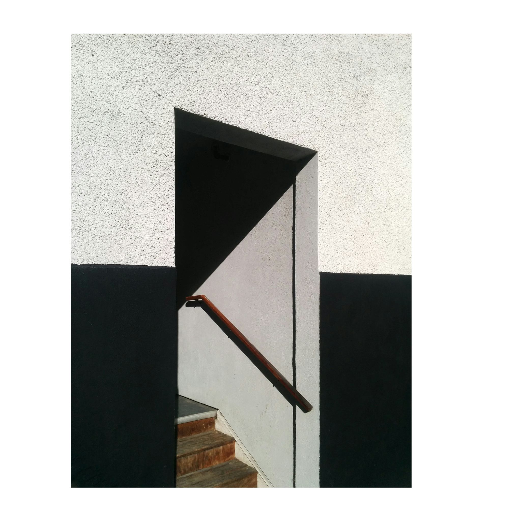door way presents the opposites of shadow on a white wall