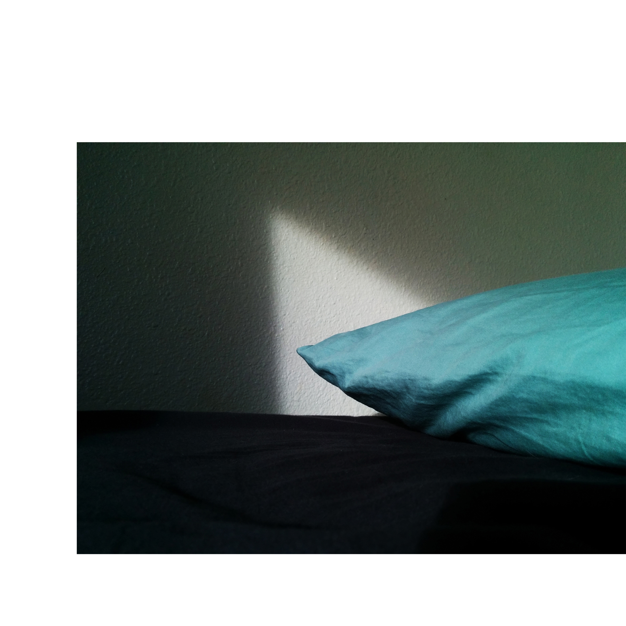 triangle of light behind a green pillow